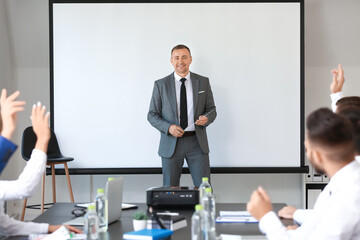Mature businessman giving presentation during meeting in office