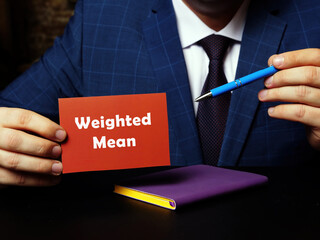 Business concept meaning Weighted Mean with sign on blank card in hand.
