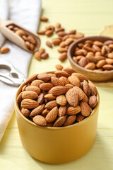 Box with tasty almonds on wooden background