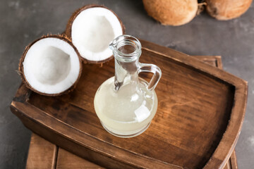Tray with decanter of coconut oil on dark background