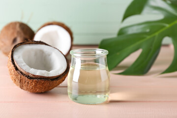 Jar of coconut oil on color wooden background