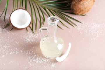 Decanter of coconut oil on color background