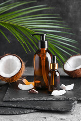 Composition with bottles of coconut oil on dark background