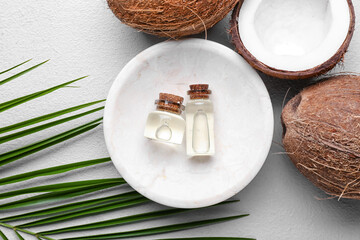 Fototapeta na wymiar Composition with bottles of coconut oil on light background