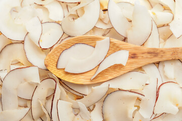 Spoon with tasty coconut chips, closeup