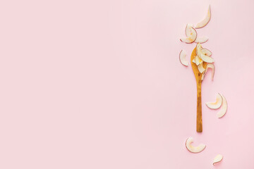Spoon with tasty coconut chips on color background