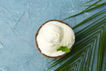 Coconut with tasty ice cream on color background