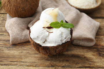 Coconut with tasty ice cream on wooden background