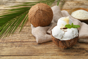 Coconut with tasty ice cream on wooden background
