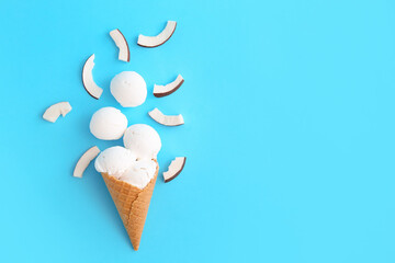 Waffle cone with tasty coconut ice cream on color background