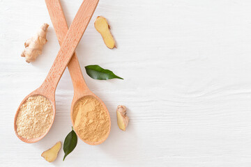 Fototapeta na wymiar Spoons with ginger powder on light wooden background
