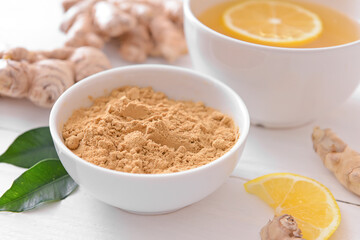 Bowl with ginger powder on light wooden background, closeup