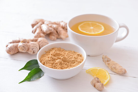 Composition with cup of ginger tea on light wooden background - Powered by Adobe