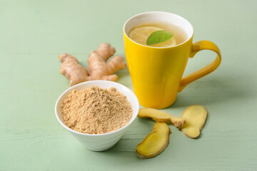 Cup of ginger tea and powder on color background