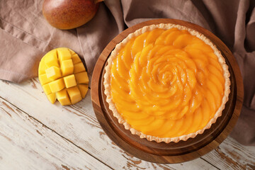 Plate with tasty mango pie on wooden background