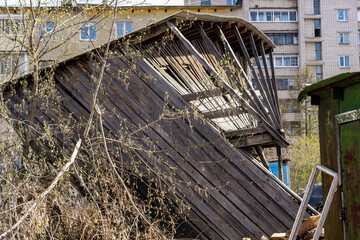 leaning wooden shed in the process of destruction