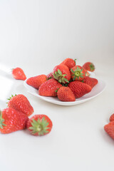 red strawberries in plate on the white table