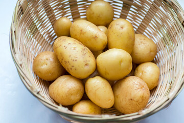 selective focus of potatoes in a bucket with white background.
