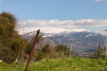 View  from the roof of ruins of crusader Fortress Chateau Neuf - Metsudat Hunin of the snow-capped peak of Mount Hermon and the valley under the mountain in northern Israel