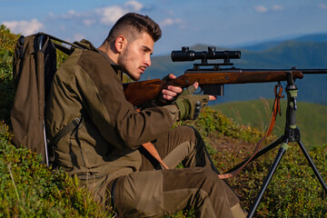 Man on the hunt. Poacher in the Forest. Hunter with shotgun gun after a hunt. Hunting rifle. Guy...
