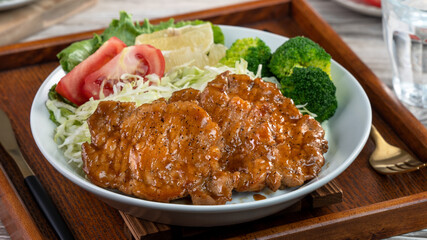 Delicious juicy pork chops with vegetables in a plate.