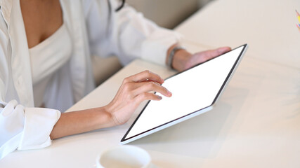 Cropped shot of young woman in casual clothes using digital tablet.