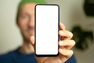 Blank smartphone screen in the hands of a young man. Man showing blank smartphone screen