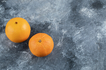 Fresh tasty oranges on marble background