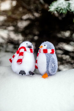 Two decorative penguins sit on the snow
