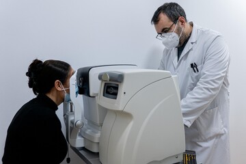 Optician measuring a woman's eyesight