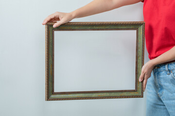 Young girl in red shirt holding a photo frame