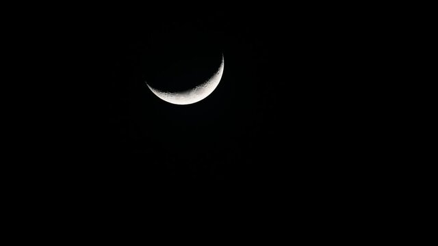 Waxing Crescent Moon, 4K Footage, seen in the middle of the frame as it slowly goes down in the middle of the night.