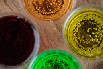 Colorful drink in plastic cups on a wooden platter