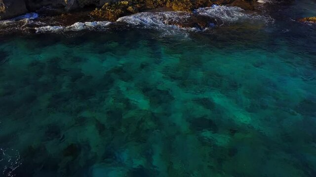 Strafe Back camera drone aerial view at south Isla Mujeres Quintana Roo Island at sunny day over the water and a beautiful landscape ocean