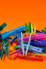 Set of colorful clothespins appearing one by one on an orange background.