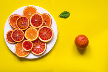 citrus fruit slices on the plate. Top view, yellow background