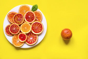 citrus fruit slices on the plate. Top view, yellow background
