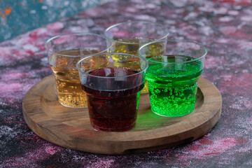 Colorful drinks in cups on a wooden platter