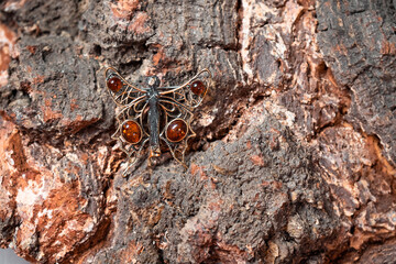 Decoration in the form of a fairy of bronze and resin against the background of a tree. High quality photo