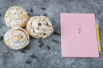Fried meringue cookie with black raisines on the grey marble background
