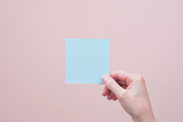 Female hand holding blank sticky memory note