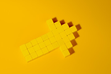 Arrow made with yellow wooden blocks. Closeup, top view. Abstract business and leadership concept