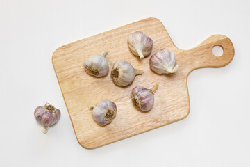 Fresh bulb garlic on the cutting board. Isolated on white background. Top view. 
