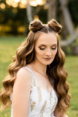 Fototapeta premium Beautiful girl with hair and makeup on the street on a sunny day