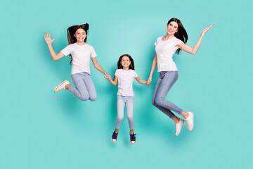 Fototapeta na wymiar Full length body size photo sisters jumping overjoyed smiling in casual outfits isolated vibrant blue color background