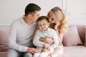 Beautiful young family man woman and son in smart clothes in a luxurious bright interior, happy family