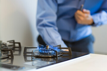 ガスコンロを点検する作業着の男性