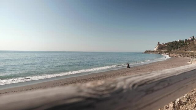 Woman walking on the beach, Torrox, Malaga, Spain, wide dolly out shot
