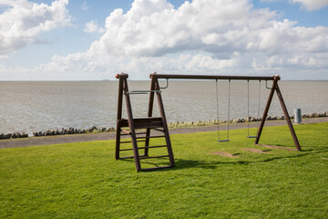 an empty swing at the coast of pellworm north sea