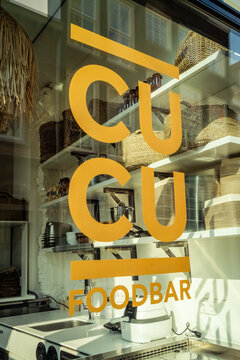 Golden logo on a window of restaurant CUCU. Moluccan restaurant CUCU lunch shop at the head of the Voorstraat in Dordrecht.